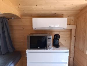 a microwave sitting on a counter in a cabin at Les roulottes de Joséphine in Veyrines-de-Domme