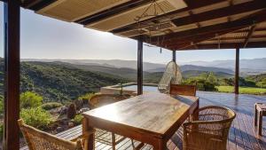 a wooden table and chairs on a deck with a view at Eldorado TopHouse in McGregor