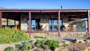 a stone house with chairs and a deck at Eldorado TopHouse in McGregor