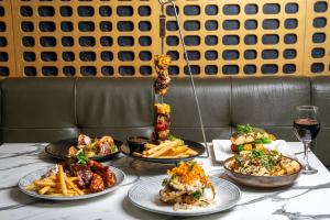 a table with plates of food and a glass of wine at Camden Hotel Suites in Camden