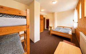 a room with two bunk beds and a table at Bouda Morava - snídaně v ceně - klidné Krkonoše in Dolni Dvur