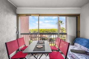 a dining room with a table and chairs and a window at T2 dans résidence arborée in Six-Fours-les-Plages