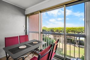 a dining room with a table and chairs and a large window at T2 dans résidence arborée in Six-Fours-les-Plages