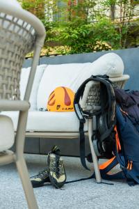 a backpack sitting next to a bed with a helmet at HB Boutique Apartment in Arco
