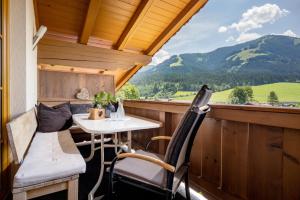 a balcony with a table and chairs and mountains at Appartement Irmgard in Brixen im Thale