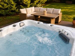 a hot tub in a backyard with a table at Phos & Kipos Villa in Koskinou