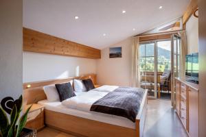 a bedroom with a large bed and a balcony at Appartement Irmgard in Brixen im Thale