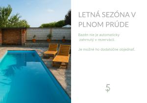 a picture of a swimming pool with two chairs at Apartments parkFIVE in Lučenec