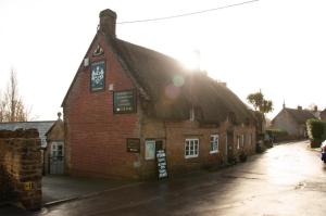 an old brick building with a sign on it at Mason's Arms in Montacute