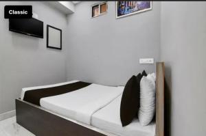 a bedroom with a bed with a tv on the wall at All sana guest house in Kolkata