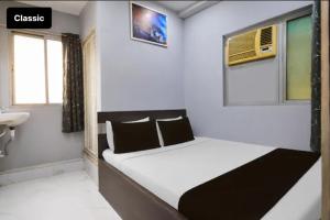 a small bedroom with a bed and a sink at All sana guest house in Kolkata