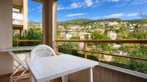 a white table and chairs on a balcony with a view at Virginia N108 - 2P4 in Grasse +3 photos