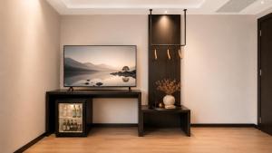 a living room with a tv on a wall at 云涧江景酒店-重庆解放碑店 Chongqing Yunjian High-altitude River View Hotel-Jiefangbei Hongyadon in Chongqing