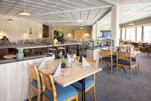 a restaurant with wooden tables and chairs and a bar at Scandic Sørlandet in Kristiansand
