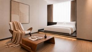 a bedroom with a bed and a chair and a table at 云涧江景酒店-重庆解放碑店 Chongqing Yunjian High-altitude River View Hotel-Jiefangbei Hongyadon in Chongqing +32 photos
