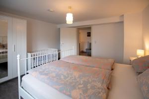 a bedroom with a white bed with a blue comforter at Ferienwohnung Auerhahn in Lauterbach