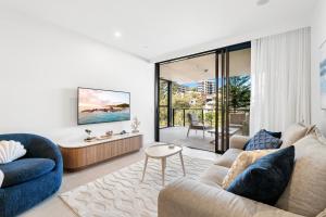 a living room with a couch and a table at Luxury Esprit Apartment at Rainbow Bay in Gold Coast