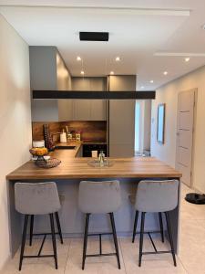a kitchen with a counter and two bar stools at Riverside Cottage in Palanga
