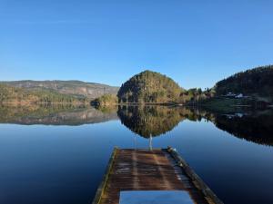 a dock in the middle of a lake at Leilighet ved vannet in Konsmo +7 photos