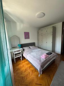 a bedroom with a large bed and a desk at Apartman Ristić in Pirot