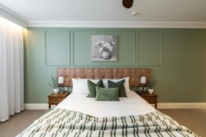 a bedroom with a large bed with green walls at Camden Hotel Suites in Camden