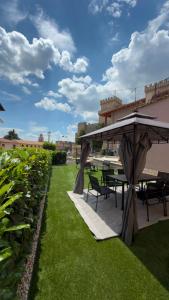 a patio with a table and chairs on the grass at Il Bijoux in Celano