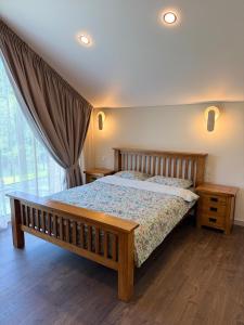 a bedroom with a wooden bed and a window at Riverside Cottage in Palanga