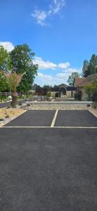 an empty parking lot in a parking lot with a building at Gite "Le Cosy Fleuri" in Champenard