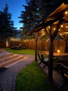 a patio with a picnic table and lights at night at Dom Gościnny in Stegna