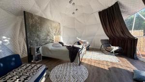 a bedroom with a bed and a chair in a tent at Saare Glamping Dome House in Salme