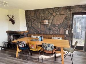 a wooden table with chairs and a stone wall at Haus Aktiv Garten2 in Winterberg