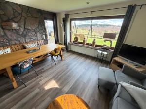 a living room with a table and a large window at Haus Aktiv Garten2 in Winterberg