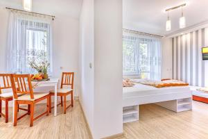 a white room with a bed and a table and chairs at WillaSimi in Władysławowo +1 photo