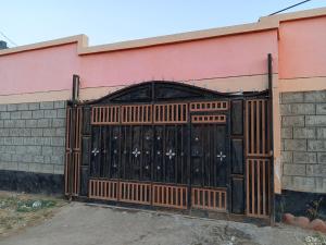 a large wooden gate on the side of a building at New Era Homes in Kimana