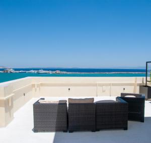 a patio with wicker chairs and a couch on a roof at Rooftop View Chios in Chios