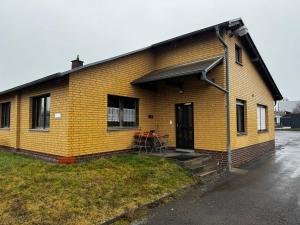 a yellow brick house with a table in front of it at Monteurzimmer Drei Gleichen in Günthersleben