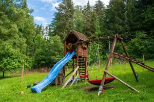 a playground with a slide and a play house at Ferienwohnung Auerhahn in Lauterbach