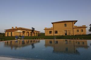 una grande piscina d'acqua di fronte a un edificio di Agriturismo Poggio Al Tufo a Pitigliano