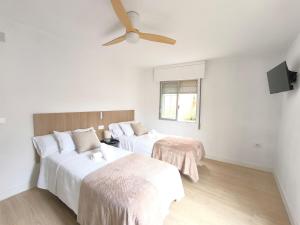 a bedroom with two beds and a ceiling fan at Casa Gaia Centrally located accommodation with spacious rooms in Redondela