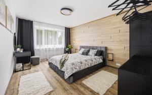 a bedroom with a bed and a wooden wall at Hygge House Elva in Elva