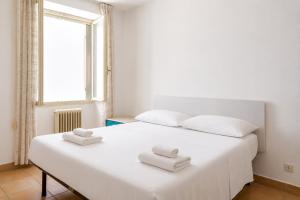 a white bed with two towels on top of it at Harbour View Apartment - Elite Grado Centro in Grado +12 photos