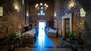 a dining room with tables and a chandelier at Agroturisme Son Cardaix in Artá