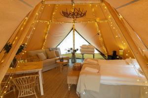 a room with a tent with a bed and a couch at Camp Gielas, Arvidsjaur in Arvidsjaur