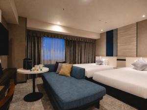 a hotel room with two beds and a couch at Hotel JAL City Nagasaki in Nagasaki +61 photos