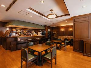 a restaurant with tables and chairs and a bar at Hotel JAL City Nagasaki in Nagasaki