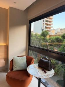 a room with a table and a chair and a window at Local Sursock in Beirut