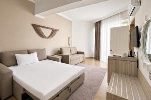 a hotel room with a bed and a couch at Rai Foresta Tekirova & SPA in Kemer