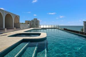 a swimming pool with the ocean in the background at Luxury Esprit Apartment at Rainbow Bay in Gold Coast