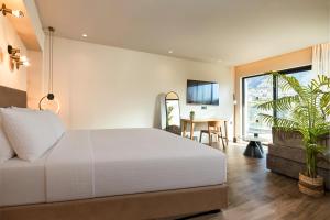 a bedroom with a large white bed and a table at Enorme Epavli Urban Living in Hersonissos