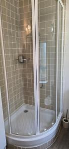 a shower with a glass door in a bathroom at Gite "Le Cosy Fleuri" in Champenard +4 photos